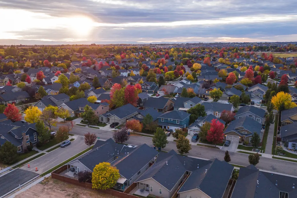 An aerial view of a Central Ohio residential neighbourhood in autumn, streets of homes under orange and red trees at sunset