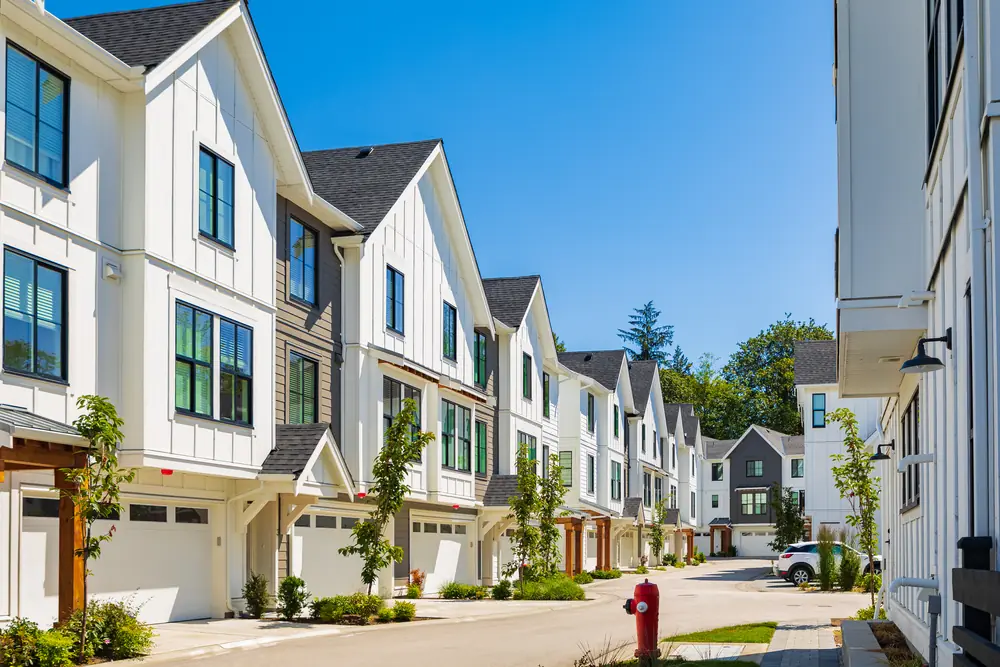 A row of newly built townhomes on a quiet residential street